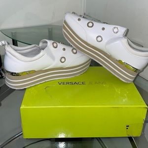 White, slip on, platform Versace sneakers with gold charms.